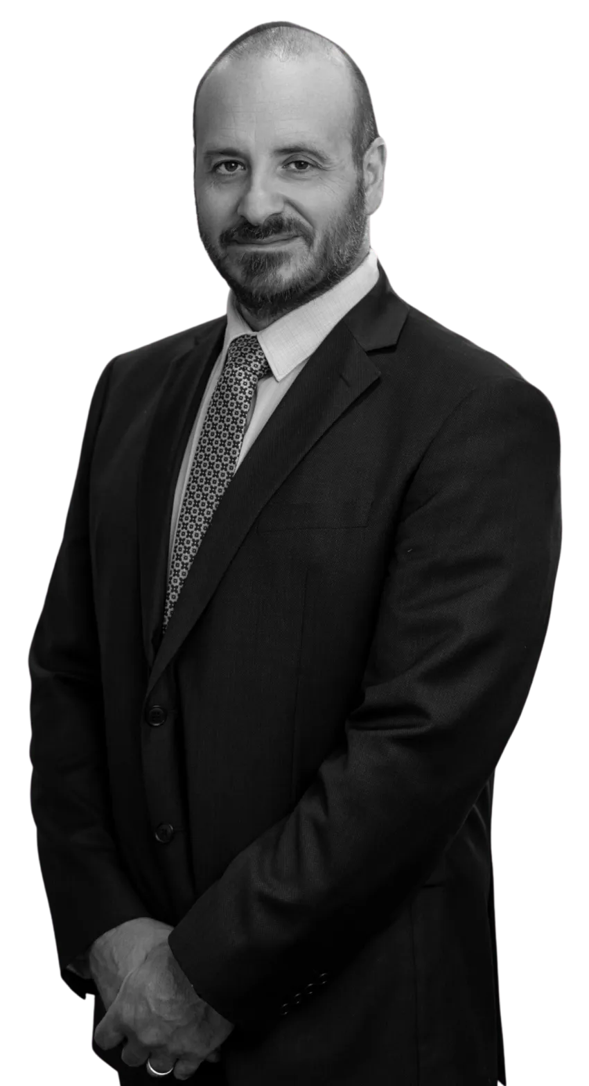 Black-and-white image of Phil Testa with a suit smiling at the camera.