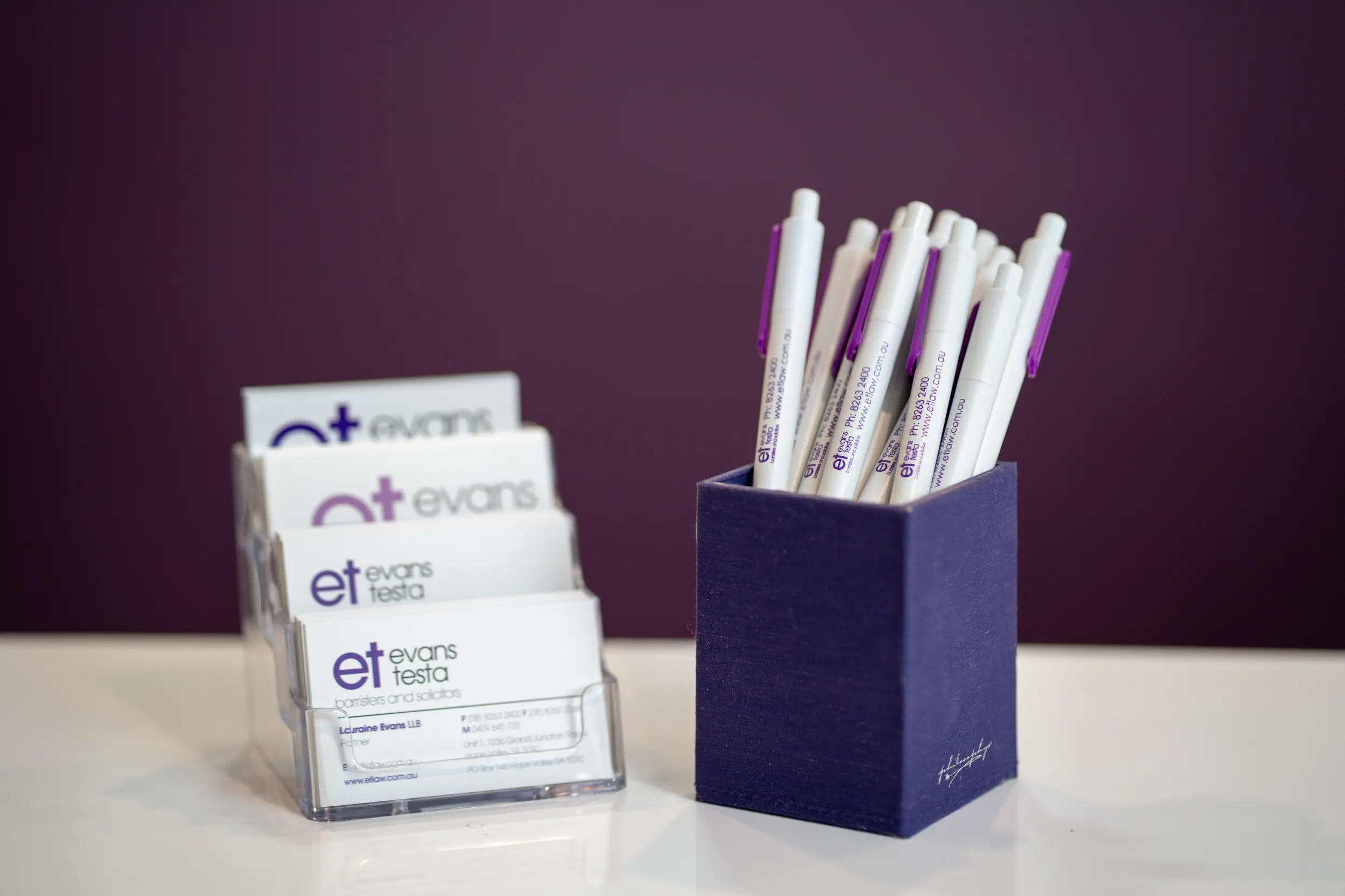 ET Law business cards and pens on a table.