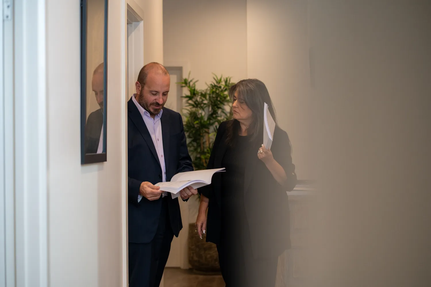 Phil Testa and Lauraine Evans discussing a case in the hallway.